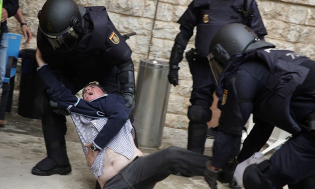 Spanish police scuffle with a man outside a polling station for the banned independence referendum in Tarragona, Spain, October 1, 2017. REUTERS/David Gonzalez