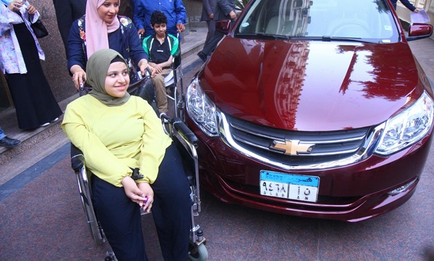The High School Student Aya Taha in front of the received car – File Photo 