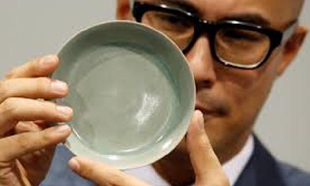 Nicholas Chow, Deputy Chairman for Sotheby's Asia and the International Head and Chairman of the Chinese Works of Art department, poses with a rare Ru Guanyao brush washer, after it sold for $37.7 million during an auction in Hong Kong, China October 3, 2