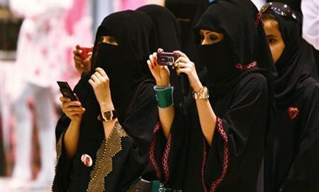 Veiled Saudi women take photos of their children during a ceremony to celebrate Saudi Arabia's - Reuters