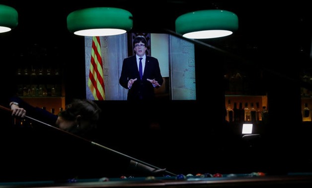 A woman plays snooker as Catalan President Carles Puigdemont makes a televised statement in Barcelona - REUTERS