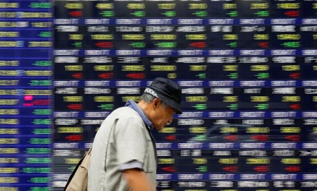 A man walks past an electronic stock quotation board outside a brokerage in Tokyo, Japan, September 22, 2017. REUTERS/Toru Hanai

