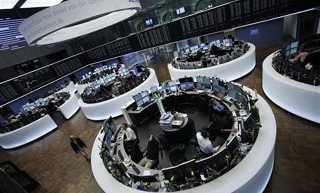 Traders work at their desks in front of the DAX board at the Frankfurt stock exchange - REUTERS