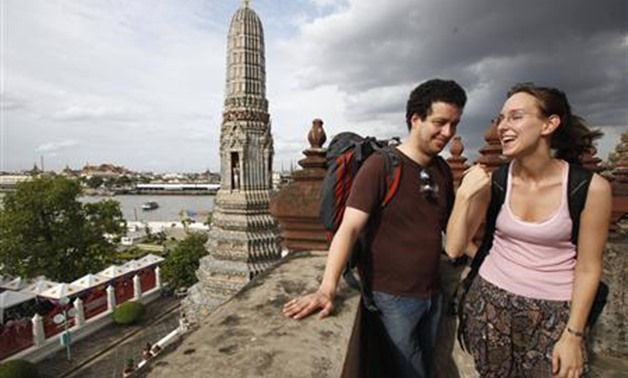 Tourists share a laugh during a visit the Temple of the Dawn in Bangkok - REUTERS
