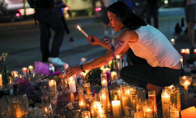 Las Vegas resident Elisabeth Apcar lights candles at a makeshift memorial at the northern end of the Last Vegas Strip, in Las Vegas, Nevada. (Photo: AFP)
