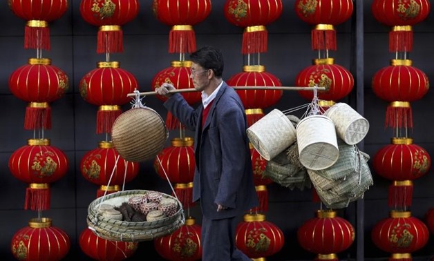 A basket vendor walks past red lanterns serving as decorations to celebrate the new year outside a shopping mall in Kunming, Yunnan province January 6, 2015. REUTERS/Stringer
