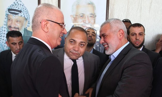 [Hamas leader Ismail Haniya (R) shakes hands with Palestinian prime minister Rami Hamdallah in Gaza City October 2, 2017- Reuters.