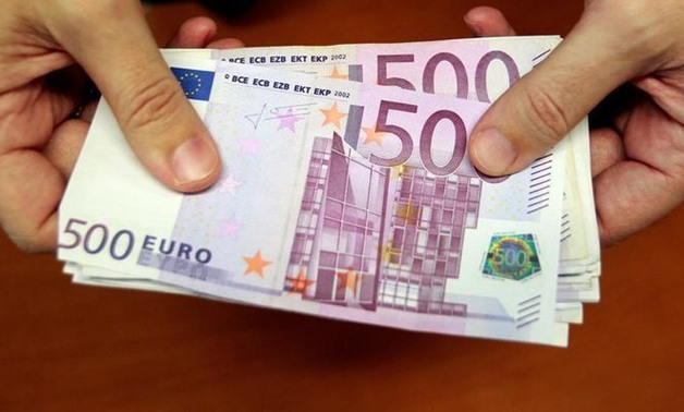 FILE PHOTO: A bank employee holds a pile of 500 euro notes at a bank branch in Madrid January 13, 2011. REUTERS-Andrea Comas-File Photo