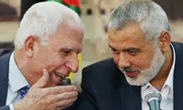 Head of Fatah delegatio to Cairo reconciliation talks, Azzam al-Ahmad (L) and Head of Hamas movement, Ismail Haniyeh (R) - Reuters