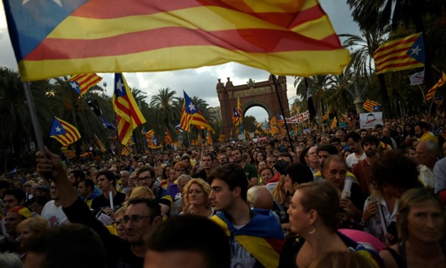 Thousands gathered outside the parliament building in Barcelona on Tuesday evening, waving Catalan flags and banners screaming 'democracy' in the hope of witnessing a historic night in a region that remains deeply divided over independence -AFP