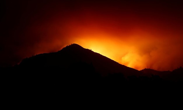 A hill is being silhouetted by flames during the Nuns Fire in Kenwood, California, U.S., October 10, 2017. REUTERS/Stephen Lam