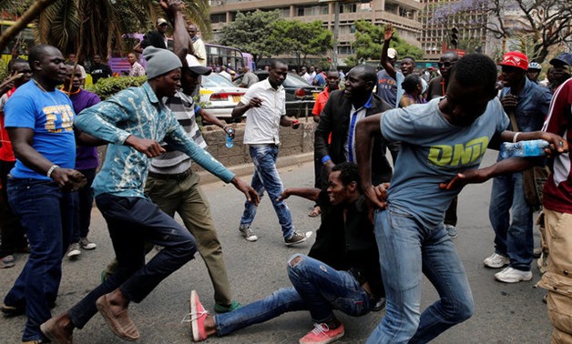 Supporters of Kenyan opposition National Super Alliance coalition accost a man suspected of stealing during a demonstration in Nairobi - REUTERS
