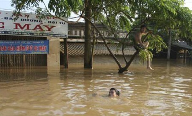 A villager swims almost submerged in flood waters in Thach Thanh district, in Vietnam's Thanh - REUTERS