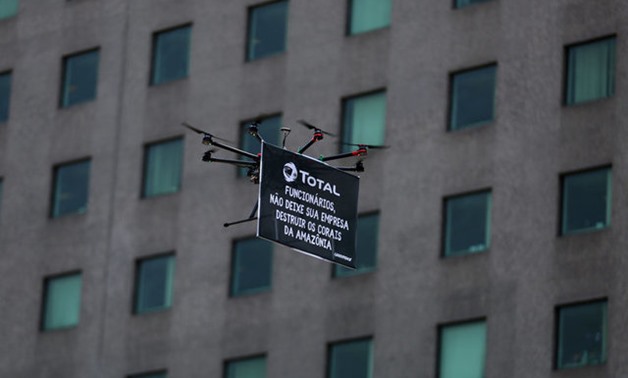 A drone from Greenpeace carrying a sign is seen with the French oil company Total's headquarters in the background, during a protest to defend the Amazon reef in Rio de Janeiro - REUTERS
