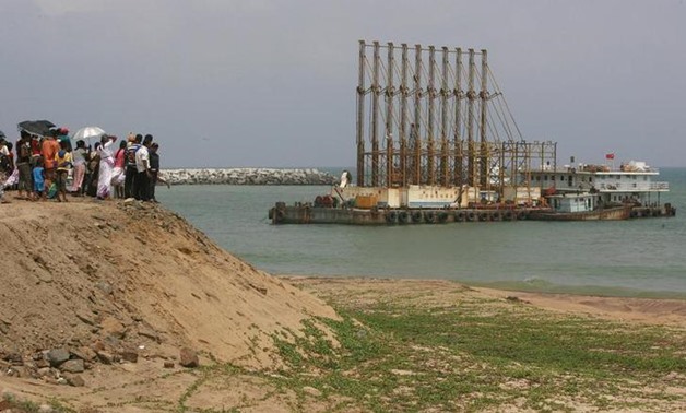 A group of Sri Lankan visitors at the new deep water shipping port watch Chinese dredging ships work in Hambantota, 240km (149 miles) southeast of Colombo, March 24, 2010 .-  REUTERS