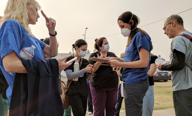 Volunteer nurses wear protective masks due to smoke from burning wildfires as they receive instructions at a shelter in Petaluma, California, U.S., October 13, 2017. REUTERS/Noel Randewich
