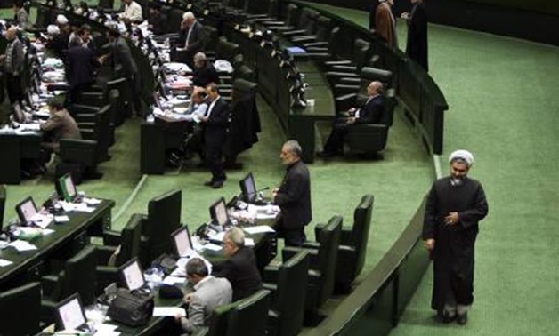 A Member of Parliament (MP) and cleric walks past during a debate at Iran's parliament to reduce ties with Britain, in Tehran November 27, 2011.