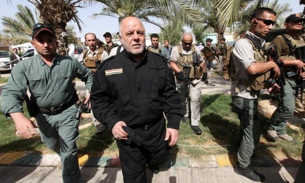 Iraq's Prime Minister Haider al-Abadi (front 2nd L) walks during his visit