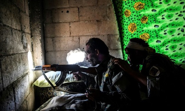 Members of the Syrian Democratic Forces (SDF) take a position inside a building on the eastern frontline of Raqa on October 5, 2017