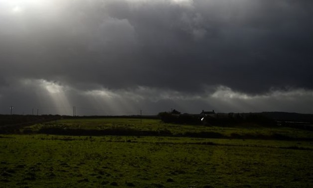 Rays of sunlight shine through dark clouds as storm Ophelia hits the County Clare town of Doonbeg, Ireland October 16, 2017. REUTERS/Clodagh Kilcoyne