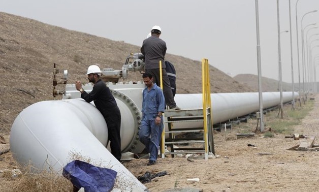 Workers adjust a valve of an oil pipe at Al Tuba oil field in Basra, southeast of Baghdad February 19, 2015. REUTERS/Essam Al-Sudani