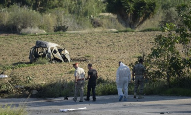 Police and forensic experts inspect the wreckage of a car bomb believed to have killed journalist and blogger Daphne Caruana Galizia close to her home in Bidnija, Malta, on October 16, 2017.