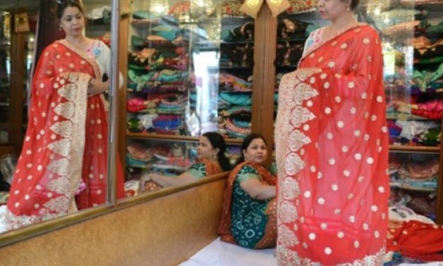 A woman looks at sarees in a store in the Indian city of Hyderabad - AFP