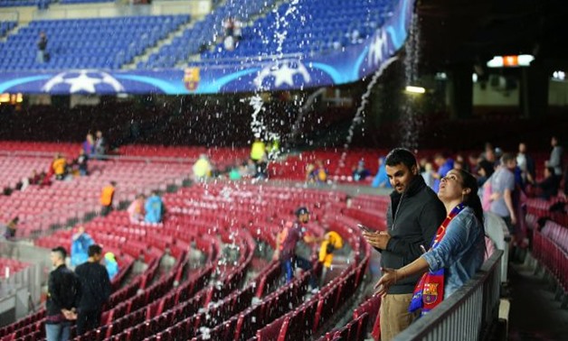 General view of the rain pouring off the stadium before the match - REUTERS