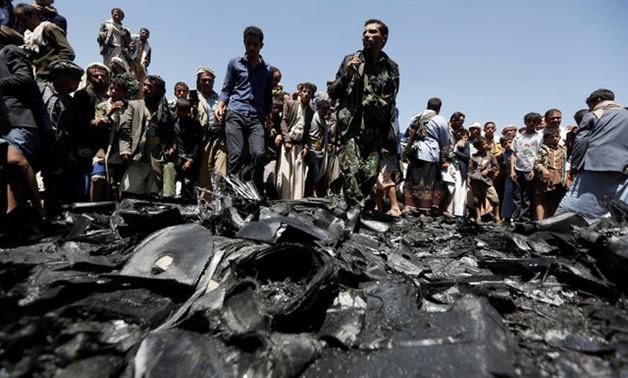 People gather at the site of the wreckage of a drone aircraft which the Houthi rebels said they have downed in Sanaa -- REUTERS