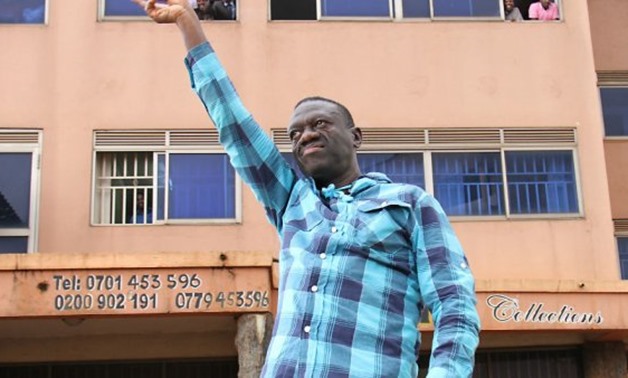 Kizza Besigye flashes the 'V-sign' on July 13, 2016 in the streets of Kampala on his way to a press conference a day after he was granted bail in his treason trial - Gael Grilhot, AFP