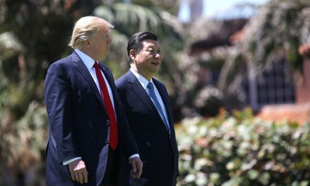 U.S. President Donald Trump (L) and China's President Xi Jinping walk along the front patio of the Mar-a-Lago estate after a bilateral meeting in Palm Beach, Florida, U.S., April 7, 2017. REUTERS/Carlos Barria
