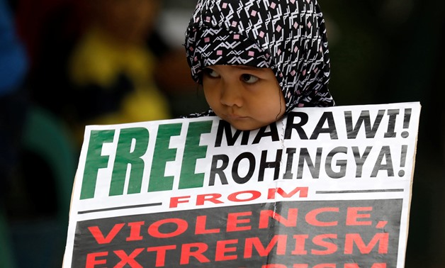 A Muslim young girl holds a placard after noon prayers for the Marawi siege and the plight of Rohingyas, in Quezon City, Metro Manila, Philippines, September 29, 2017. REUTERS/Dondi Tawatao