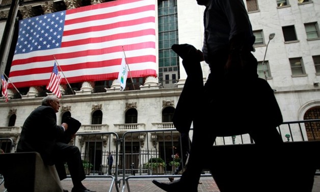Morning commuters are seen outside the New York Stock Exchange - REUTERS
