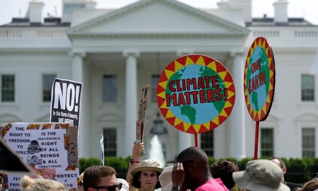 Protesters carry signs during the Peoples Climate March at the White House in Washington, U.S., April 29, 2017. REUTERS/Joshua Roberts
