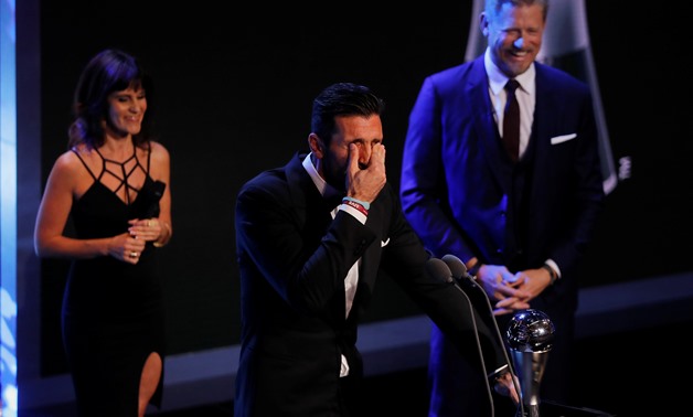 Juventus’ Gianluigi Buffon reacts as he is presented with The Best FIFA Goalkeeper Award by former Manchester United player Peter Schmeichel during the awards REUTERS/Eddie Keogh