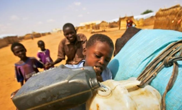 South Sudanese refugees fill water jugs at Al-Nimir refugee camp in Sudan's east Dafur in June 2017. Some 461,000 refugees have arrived in Sudan since December 2013 when a brutal civil war erupted in South Sudan. By ASHRAF SHAZLY - AFP/File