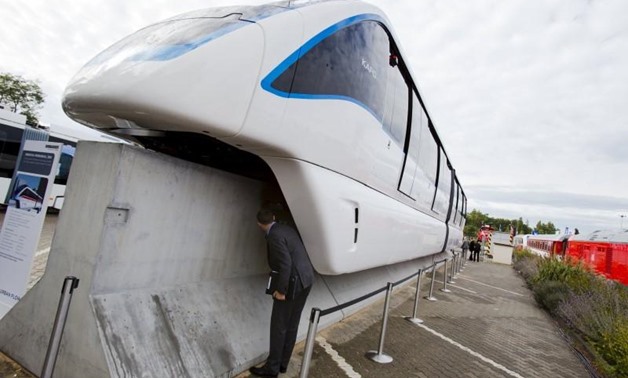 A man looks underneath an Innovia Monorail 300 train by Bombardier Transportation at the InnoTrans railway technology trade fair in Berlin - REUTERS