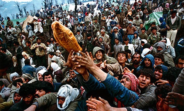 By Isabel Coles PAST: Kurdish refugees struggle for a loaf of bread distributed as part of a humanitarian aid effort in 1992. REUTERS/Yannis Behrakis