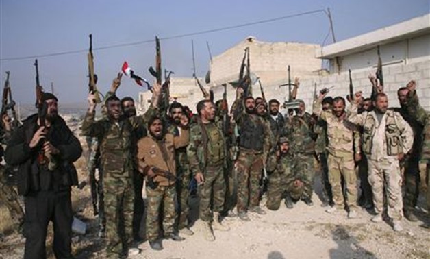Forces loyal to Syria's President Bashar al-Assad hold up their weapons as they cheer in the town of Safira - REUTERS