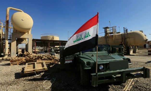 An Iraqi flag is seen on a military vehicle at an oil field in Dibis area on the outskirts of Kirkuk - REUTERS