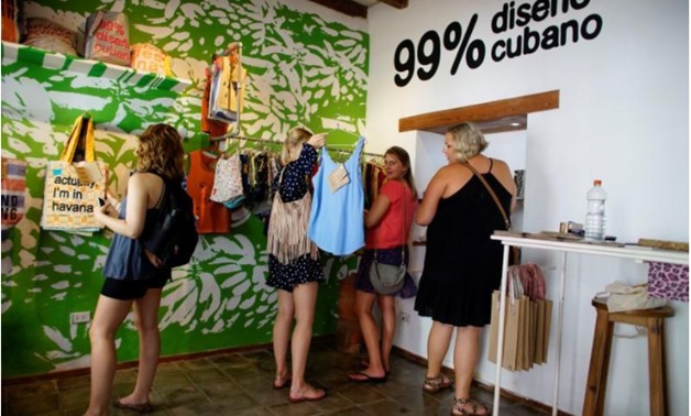 U.S. tourists look at products inside the Cuban private design store Clandestina in Havana, Cuba, October 23, 2017 - REUTERS/Alexandre Meneghini
