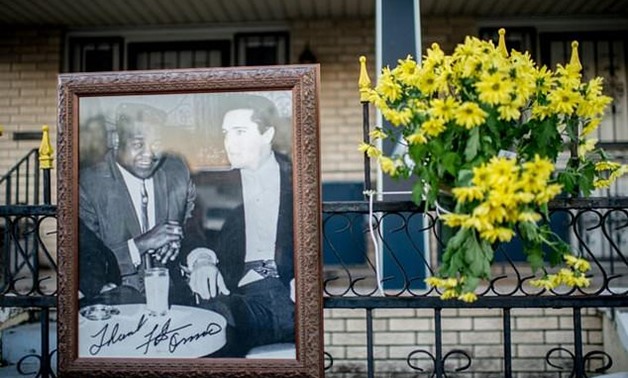 A photo of Fats Domino and Elvis Presley sits on the fence at Fats Domino's memorial outside of his old home in the Lower 9th Ward in New Orleans - AFP