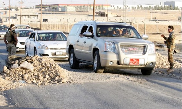 Kurdish Peshmerga fighters stand at a checkpoint north of Kirkuk - REUTERS