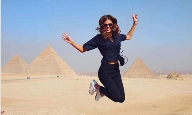 Miss universe cheerfully jumping in front of the Pyramids of Giza – photo from Iris Mittenaere's official Instagram account