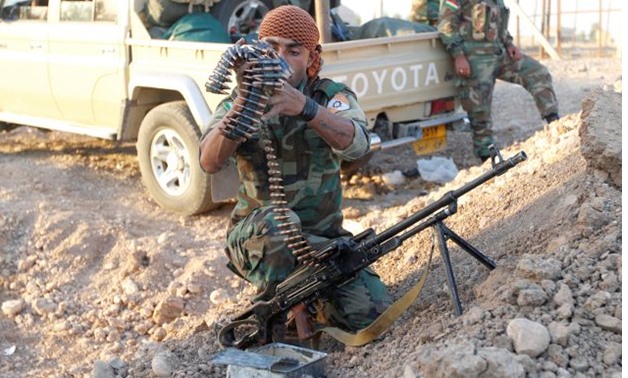 Member of Kurdish Peshmerga fighters check his weapon north of Kirkuk - REUTERS