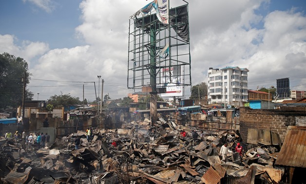 People inspect the damage as they stand amid the remains of properties that were burnt by rioters in Kawangware slums in Nairobi, Kenya October 28, 2017. REUTERS/Thomas Mukoya