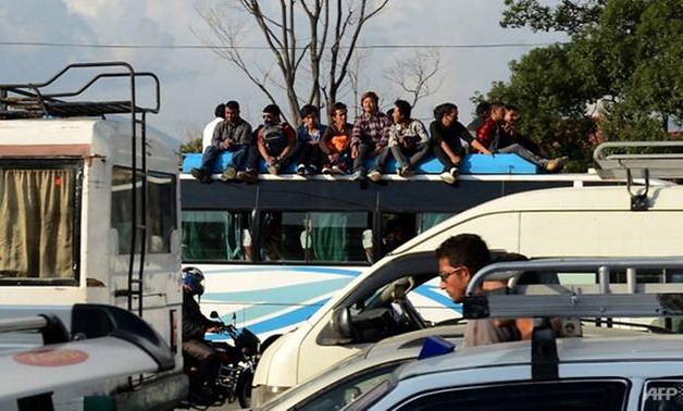 File photo of Nepalese commuters travel atop a public bus. (Photo: AFP / PRAKASH MATHEMA)