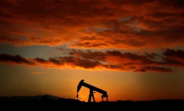 An oil pump jack is seen at sunset in a field outside Scheibenhard, near Strasbourg, France, October 6, 2017. REUTERS/Christian Hartmann