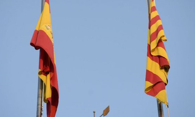  Spanish and Catalan flags are pictured on top of the 'Generalitat' palace (Catalan government headquarters) in Barcelona - AFP