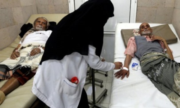Yemeni men suspected of being infected with cholera receive treatment at a makeshift hospital in Sanaa - AFP